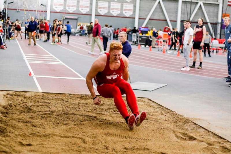 a man in red uniform running on a track