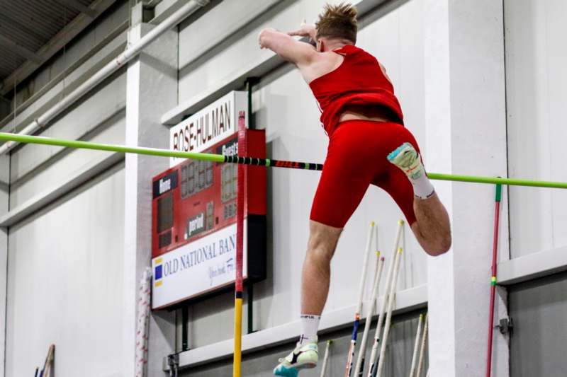 a man jumping over a pole