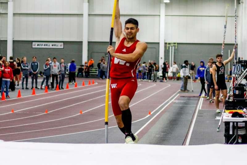 a man holding a pole in a track