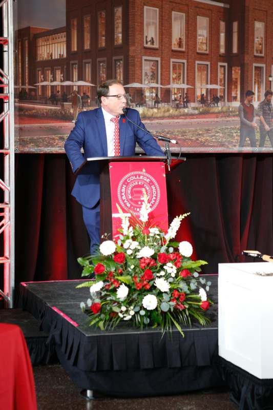 a man standing at a podium with a microphone