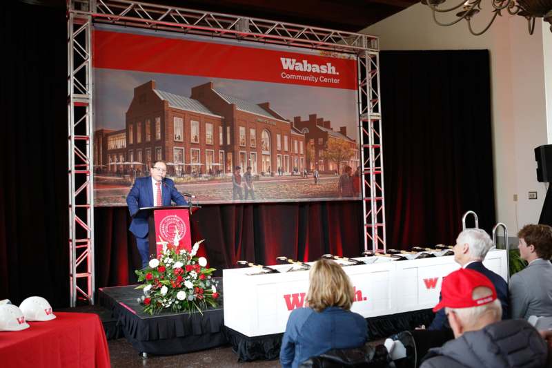 a man standing at a podium with a podium and a group of people