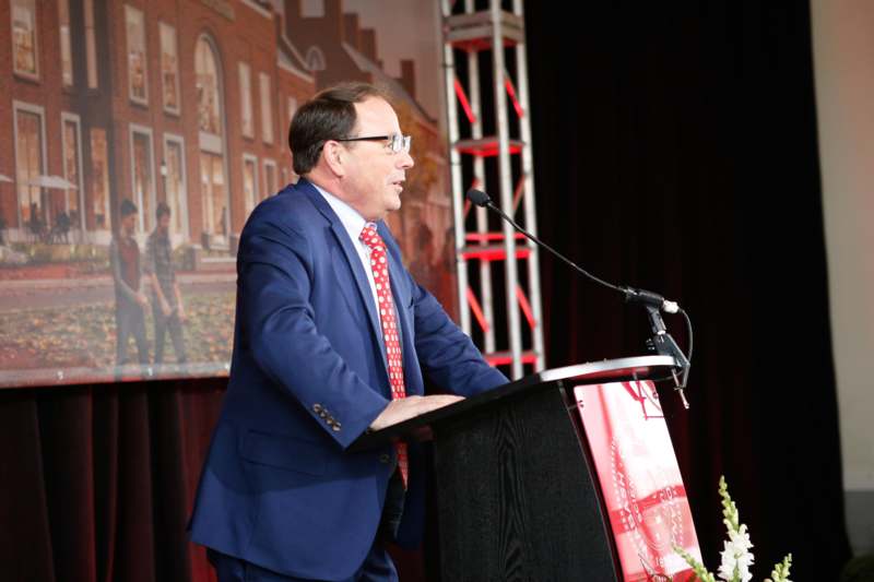 a man in a suit speaking into a microphone