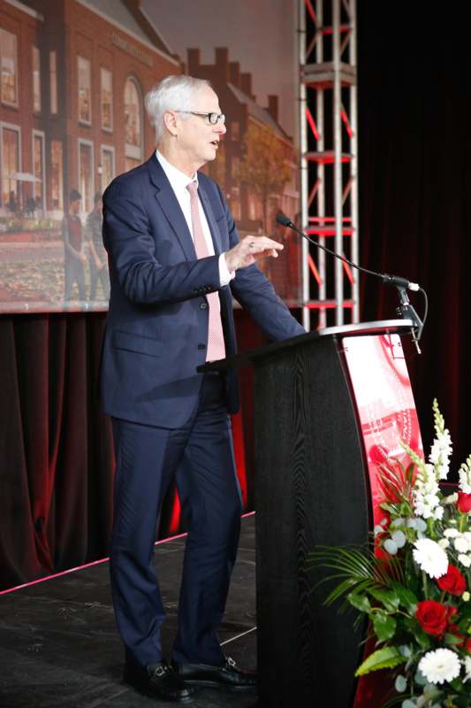 a man standing at a podium with a microphone