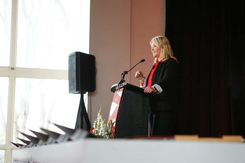 a woman standing at a podium with a microphone