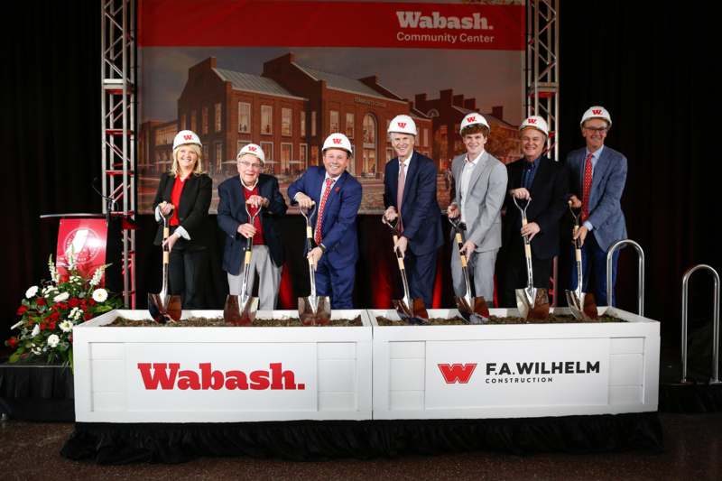 a group of people wearing helmets holding shovels