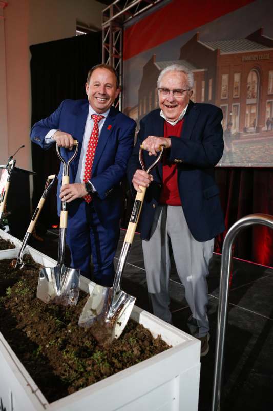 two men holding shovels in a box