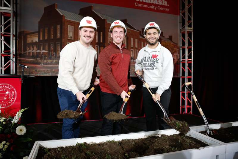 a group of men holding shovels and dirt