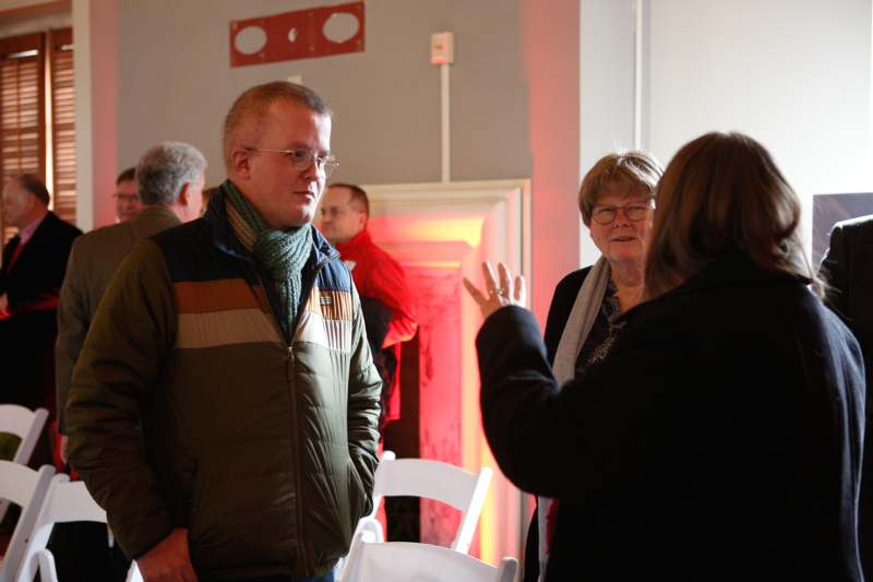 a man standing in a room with a group of people