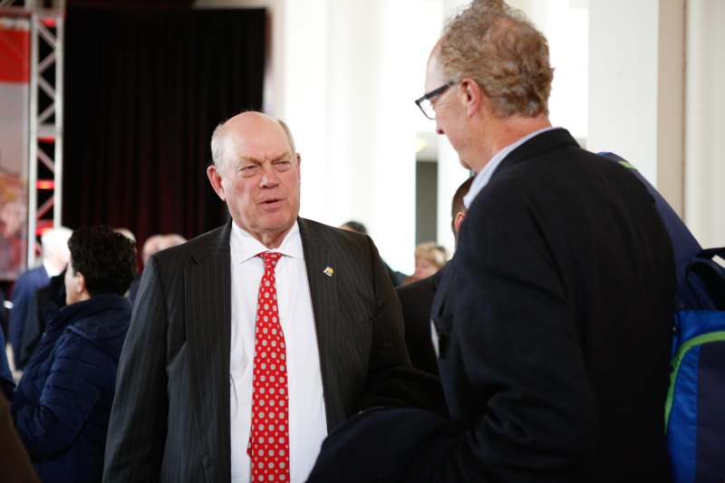 a man in a suit talking to another man