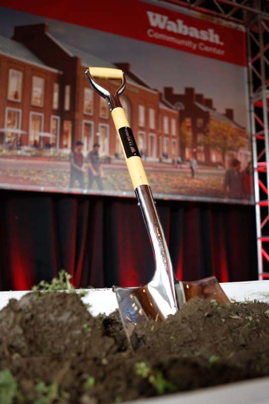 a shovel in dirt with a picture of people in the background