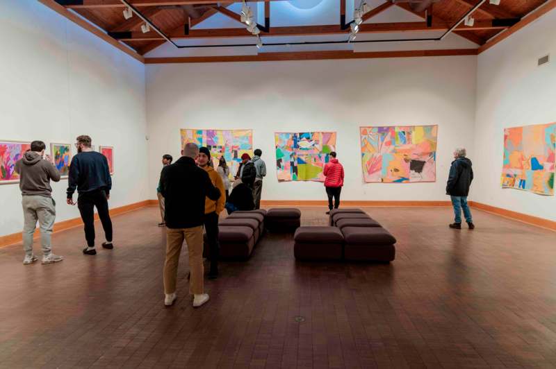 a group of people in a room with art on the wall