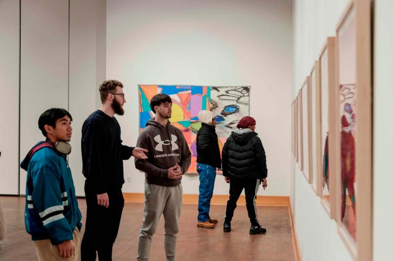 a group of people looking at a painting