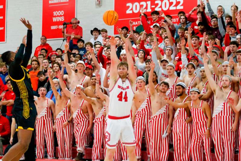 a basketball player in uniform with a crowd of people in the background