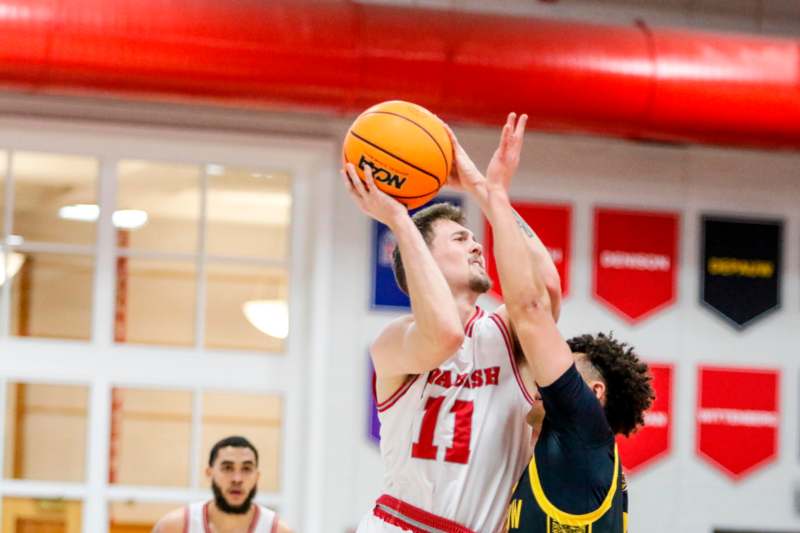 a man in a basketball uniform with a basketball in the air