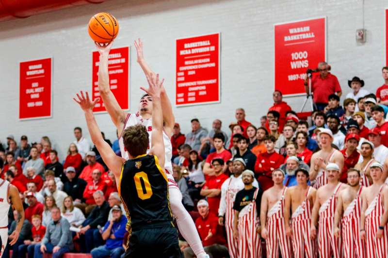 a basketball player in a uniform jumping to block a basketball