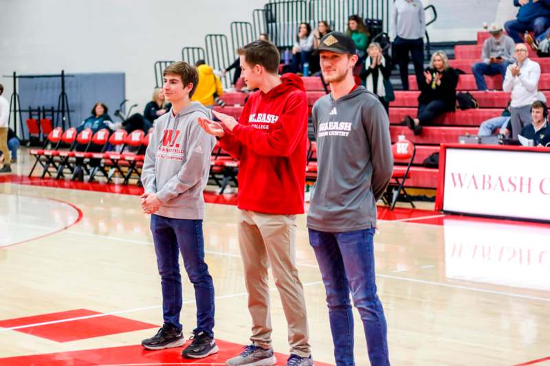 a group of men standing on a basketball court