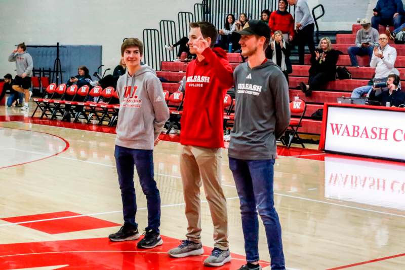 a group of men standing on a basketball court