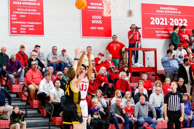 a basketball player shooting a ball in front of a crowd