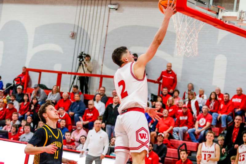 a basketball player dunking a basketball in front of a crowd