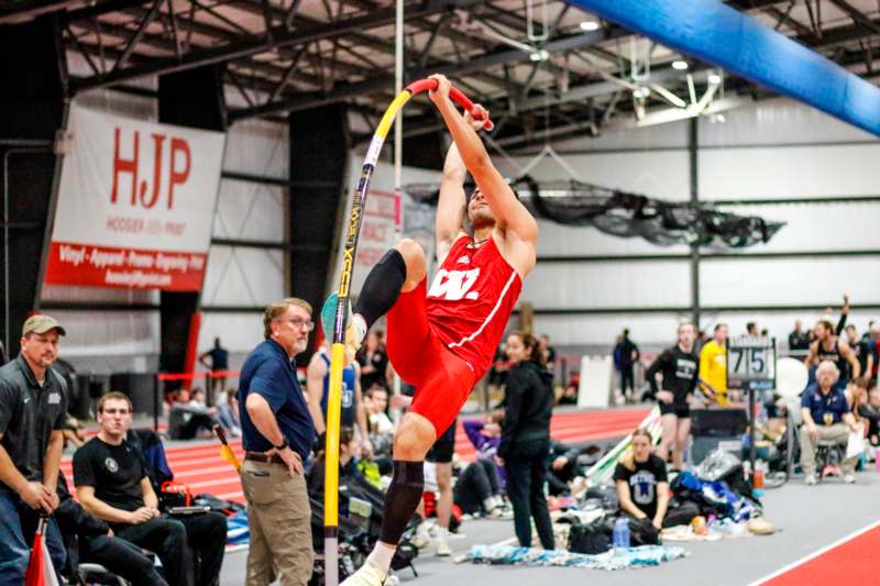 a man in red shorts holding a pole in the air