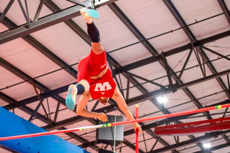 a man jumping over a pole