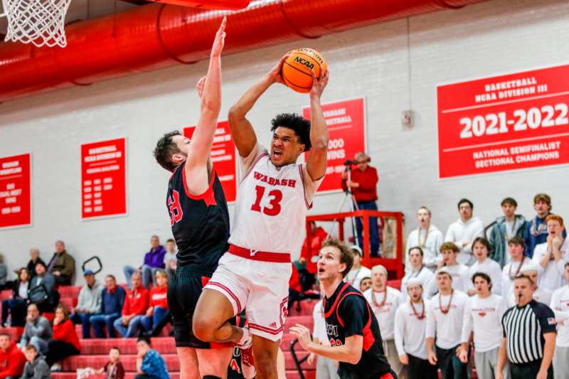 a basketball player in a red uniform jumping to block a basketball