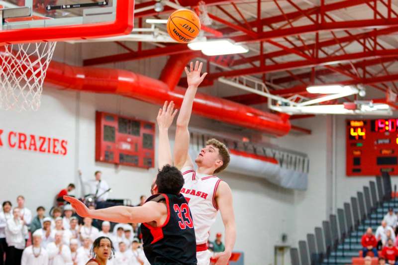 a basketball player reaching for a ball