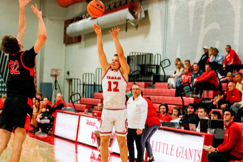 a man in a basketball uniform jumping to shoot a basketball