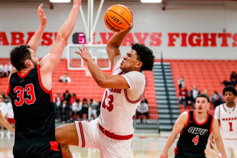 a basketball player in a red uniform jumping to block a basketball