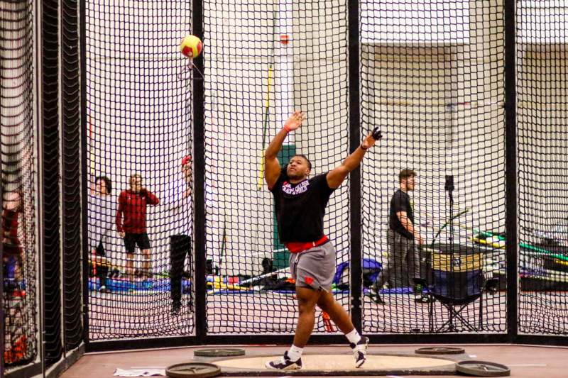 a man throwing a ball in a gym