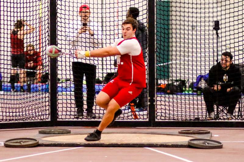 a man in a red uniform hitting a ball with a hammer