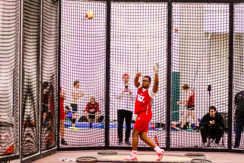 a person throwing a ball in a cage