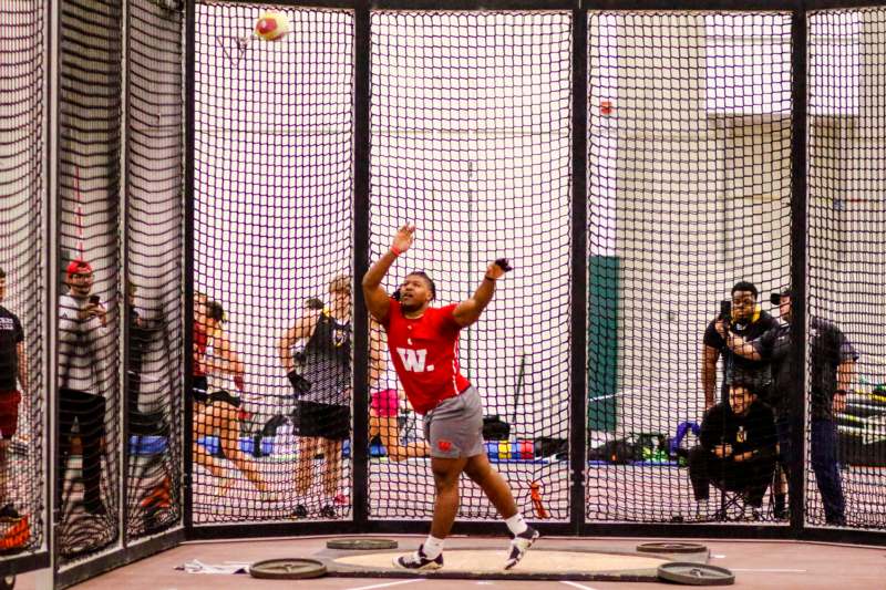 a man in a red shirt in front of a net