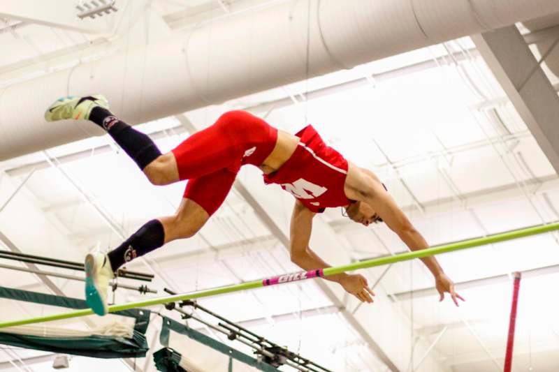 a man jumping over a pole