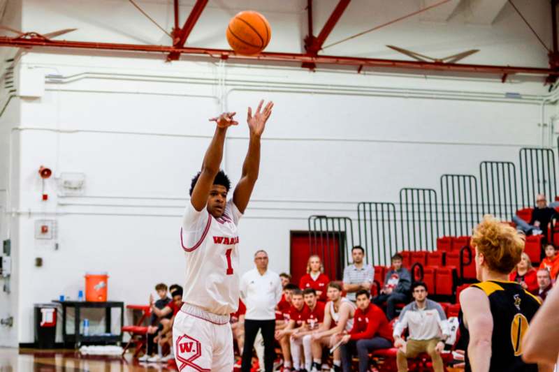 a man in a white uniform jumping to shoot a basketball