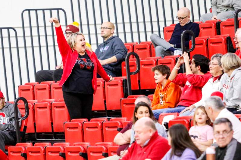 a woman in a red jacket in a stadium