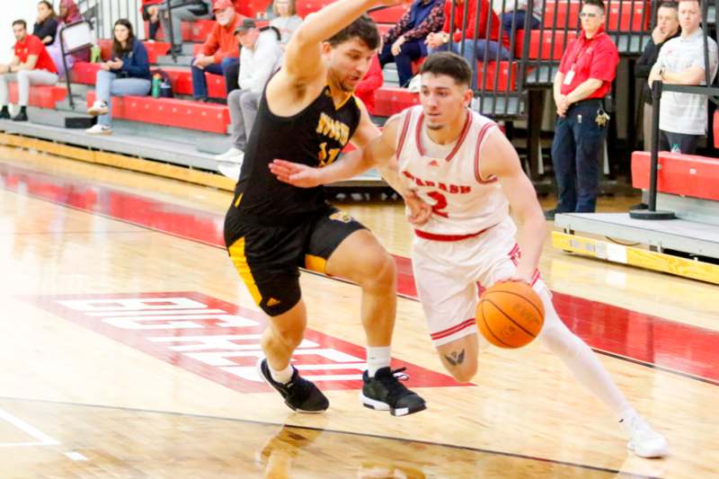 two men playing basketball in a gym