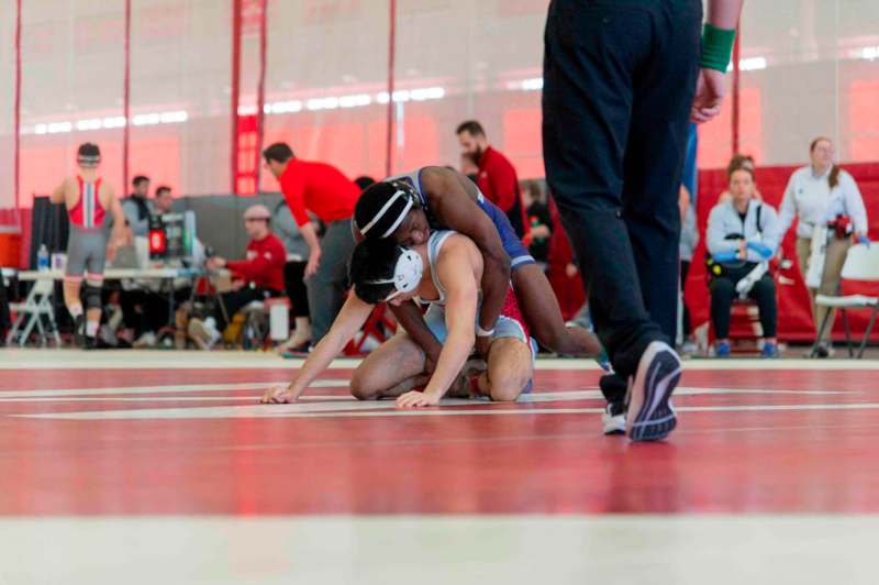 a group of people wrestling on a red floor