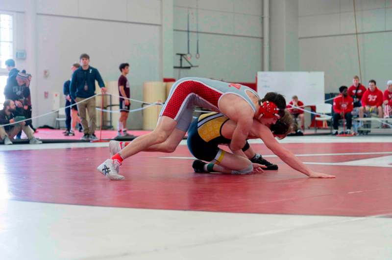 a group of people wrestling on a red mat