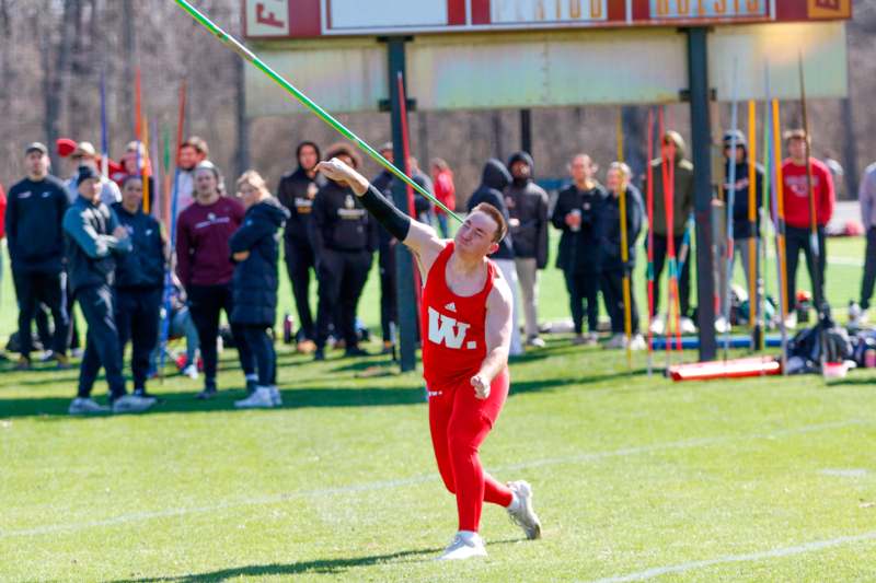 a man in a red uniform throwing a javelin