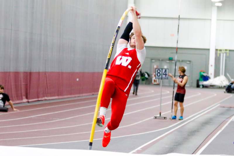 a man in a red uniform holding a pole in the air