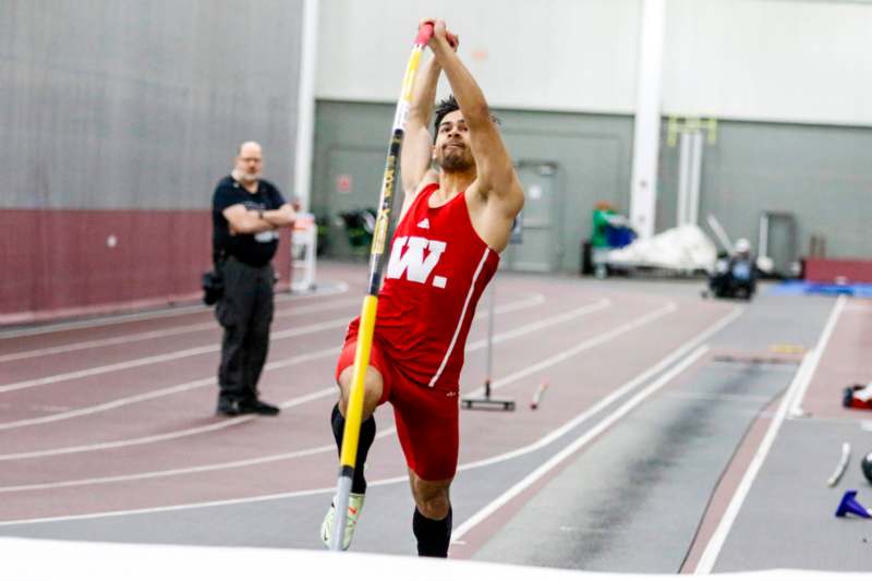 a man holding a pole in a track