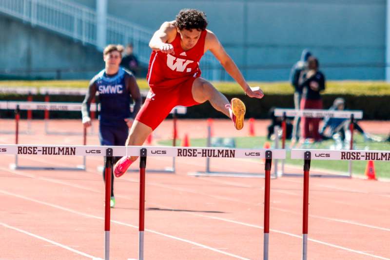 a man jumping over a hurdle