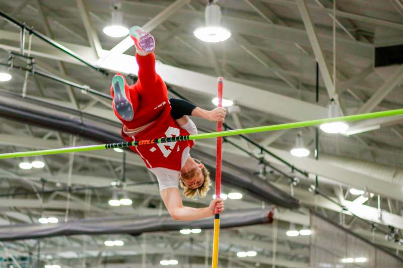 a man in red shirt holding a pole in the air