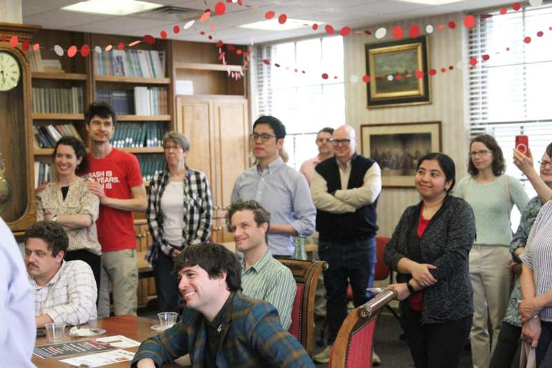 a group of people standing around a table