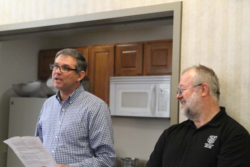 a couple of men standing in a kitchen