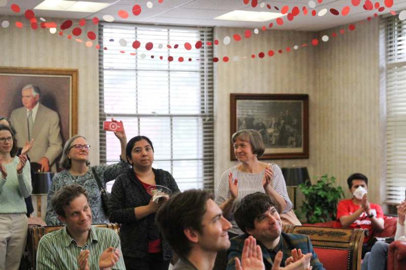 a group of people in a room clapping