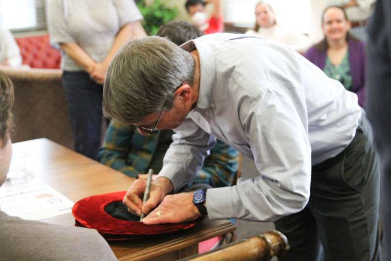 a man signing a hat