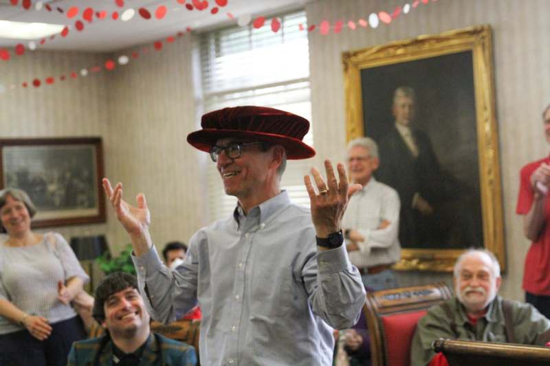 a man in a hat with his hands up