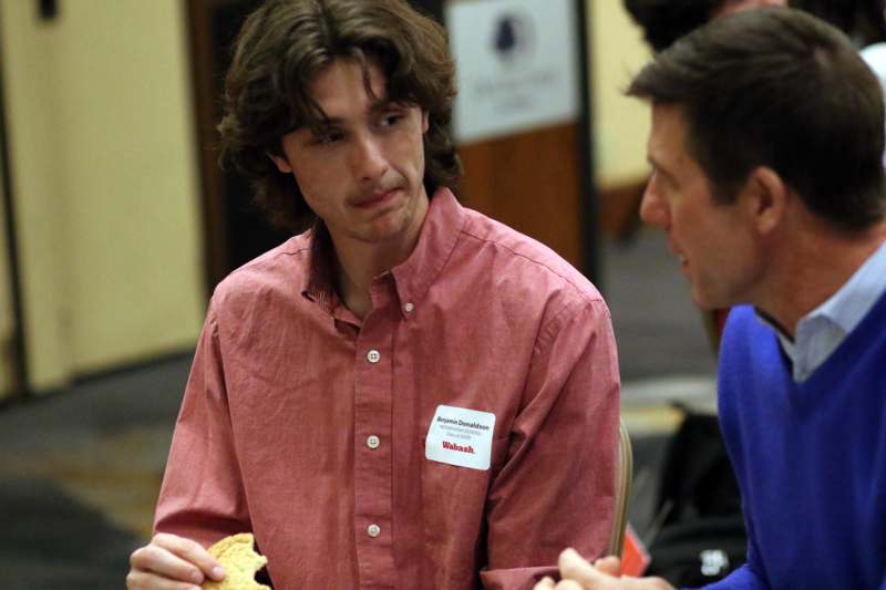 a man in a red shirt holding a piece of food